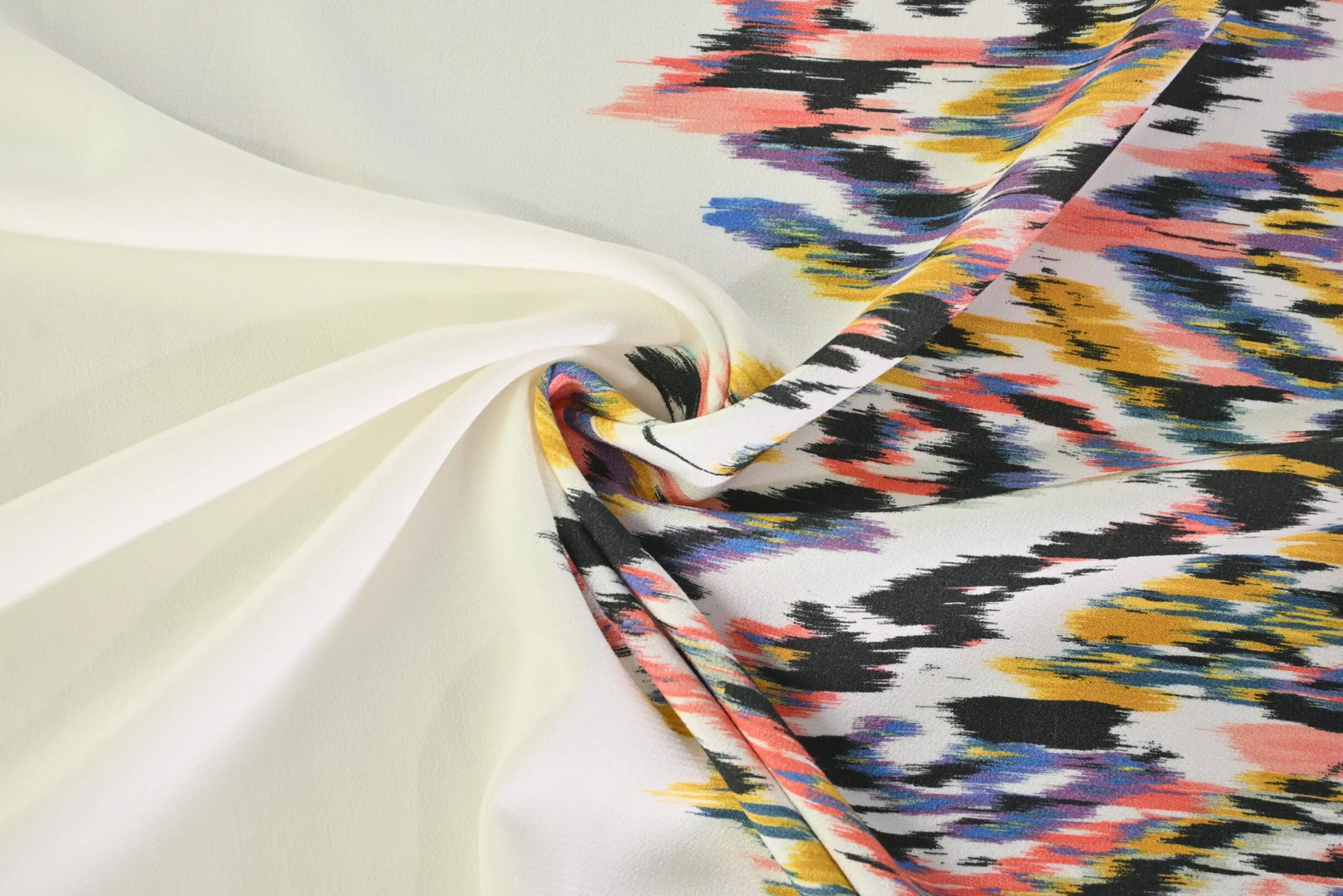 Viscose stretch crêpe – Kleurrijke ikat op gebroken wit randdesign