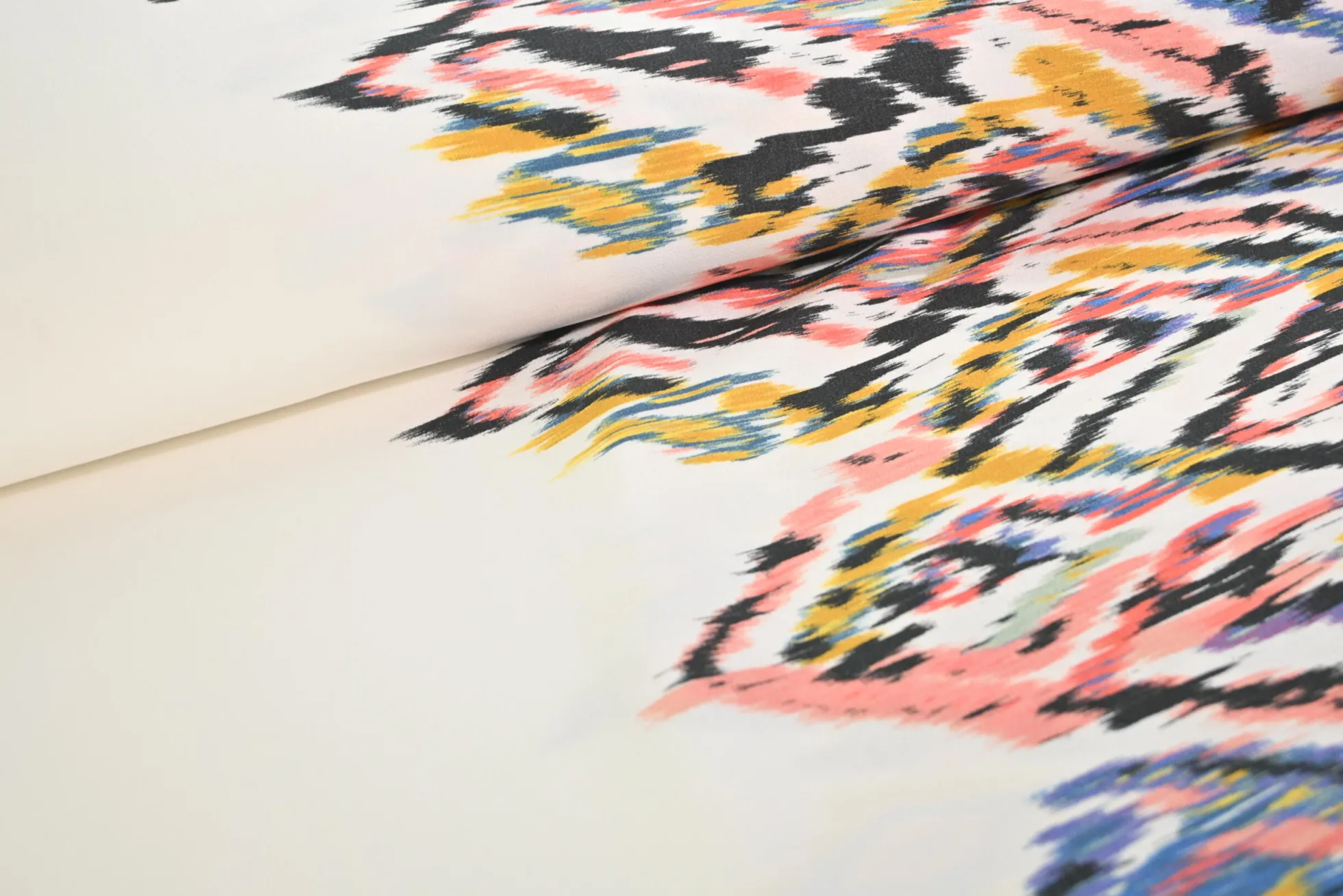 Viscose stretch crêpe – Kleurrijke ikat op gebroken wit randdesign