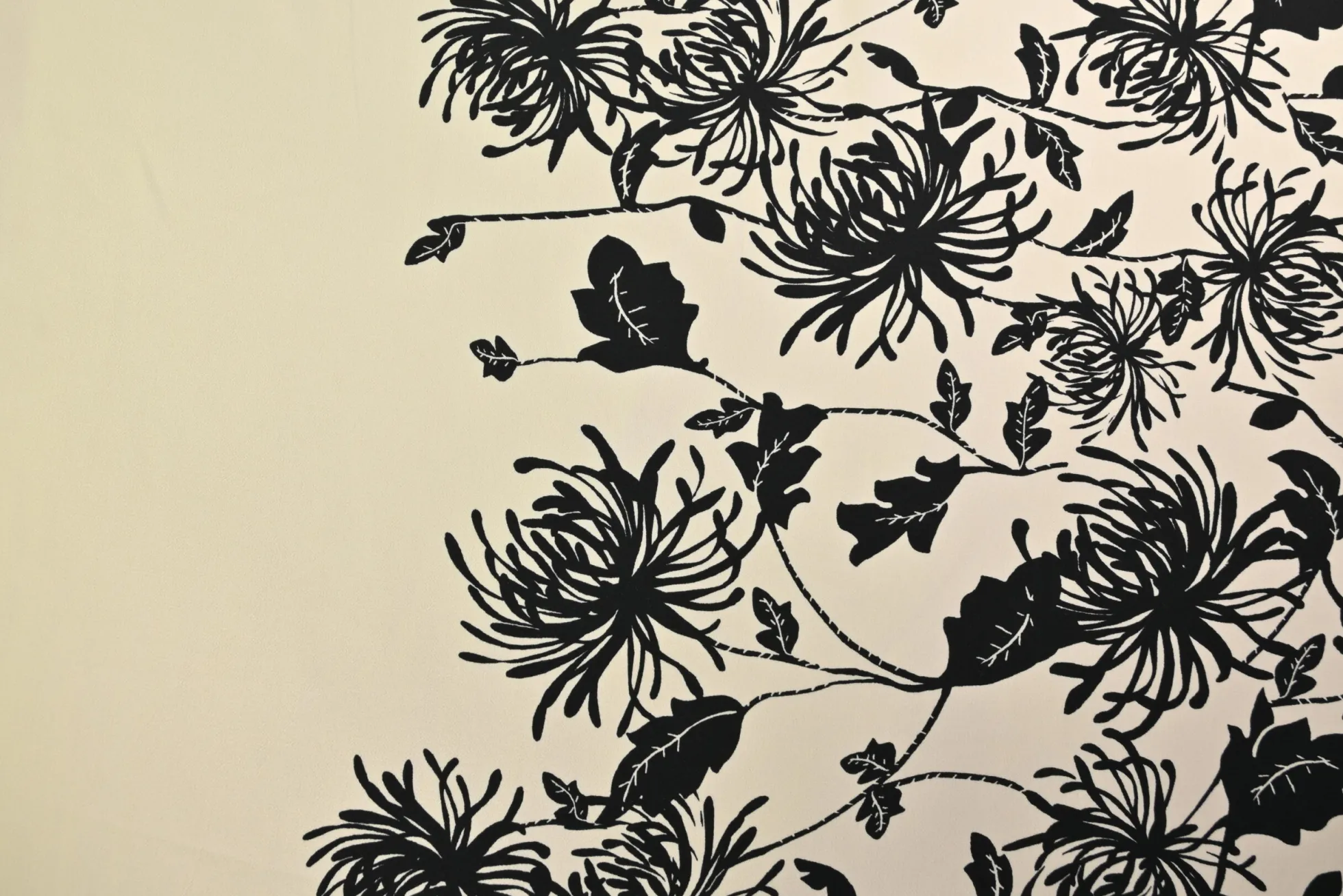 Viscose stretch crêpe – Zwarte bloem op champagne randdesign